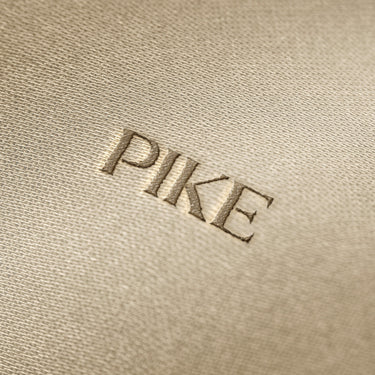 Soft beige fabric close-up showing a smooth, heavyweight knit texture with gentle folds and subtle draping.
