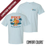 Light blue short sleeve Comfort Colors tee featuring Pi Kappa AlphaÕs golden retriever mascot on the back, lounging on a beach with palm trees and a sunset. Front chest print includes PIKE letters and a small beach ball detail.