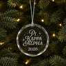 Limited Edition glass Christmas ornament with engraved design hanging on a decorated holiday tree