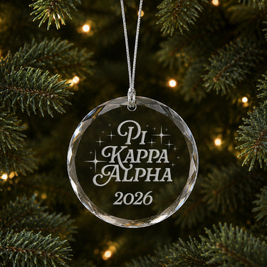 Limited Edition glass Christmas ornament with engraved design hanging on a decorated holiday tree